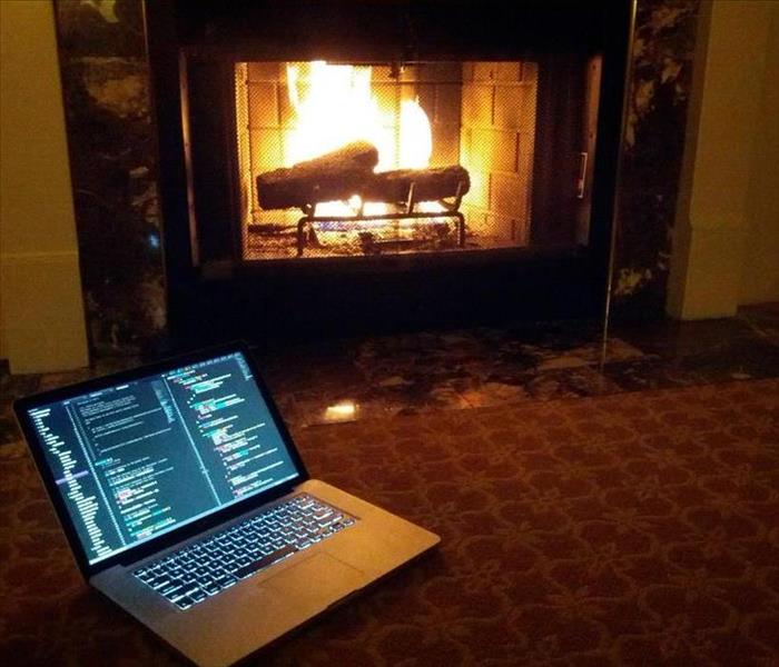 Laptop next to a fireplace